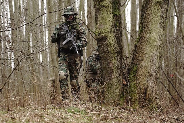 Man walking through woods with an airsoft gun