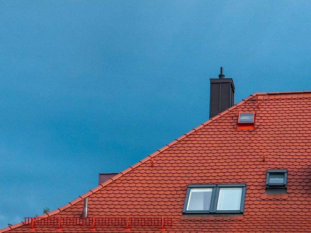 A house roof in red color with glass windows